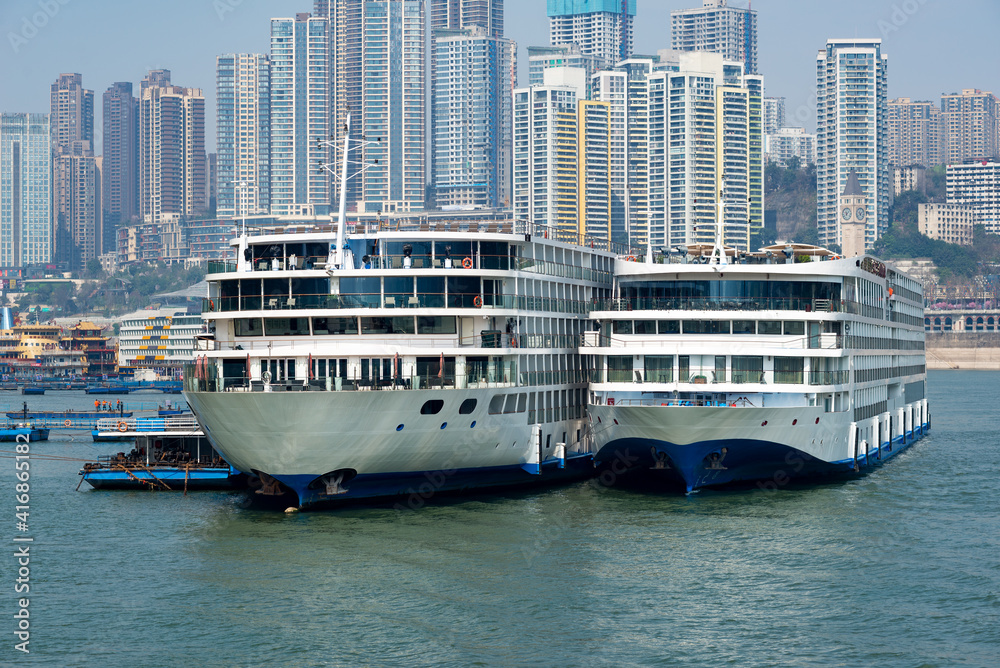 Luxury cruise ships sailing on the Yangtze River, the city skyline in Chongqing, China