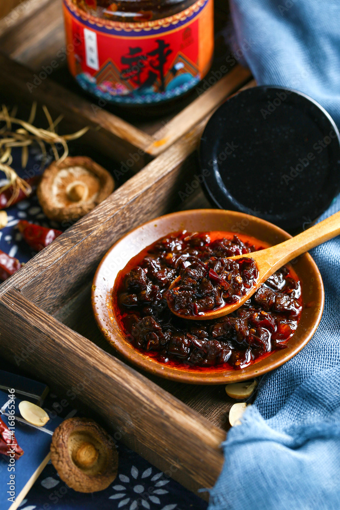 A wooden spoon to scoop up a spoonful of Sichuan chili sauce A wooden spoon to scoop up a spoonful of Sichuan chili sauce