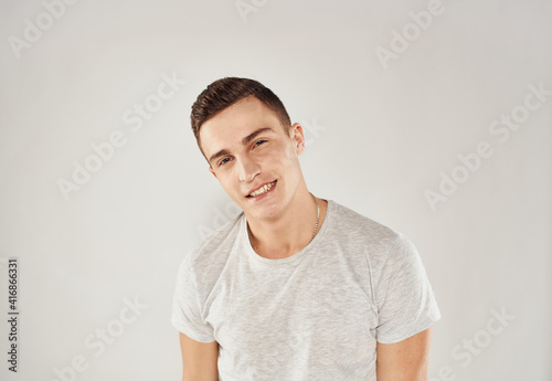 Man in white t-shirt emotions studio cropped view light background