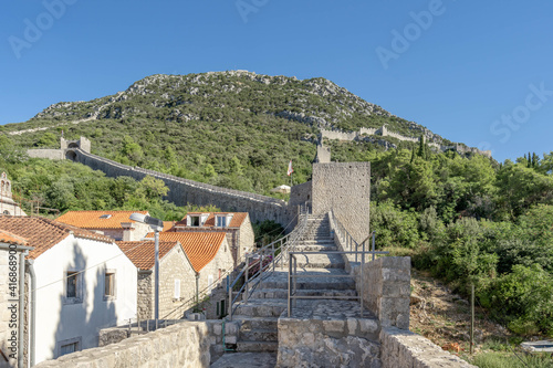 Narrow stone passage stairs on Wall of Ston aong hills in Croatia summer sunny morning