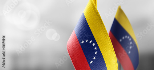 Small national flags of the Venezuela on a light blurry background photo