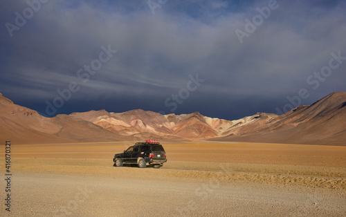 Four-wheel car with the beautiful palette of colors in the Salvador Dali Valley, Salar de Uyuni, Bolivia