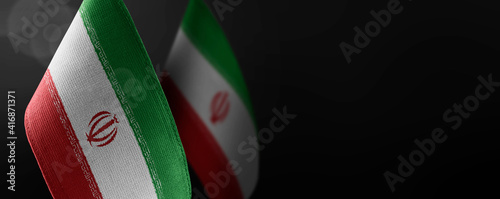 Small national flags of the Iran on a dark background photo