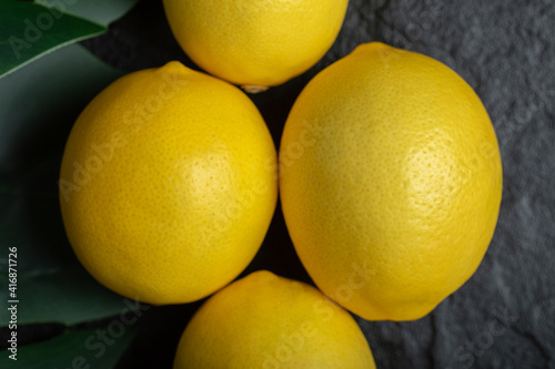 Close up photo of fresh ripe lemons on black background