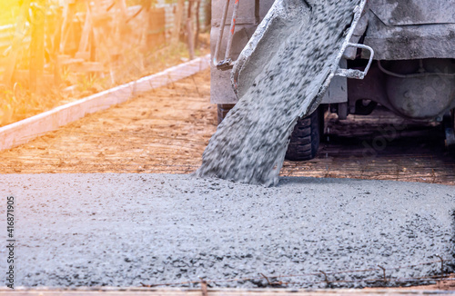 Pouring ready-mixed concrete after placing steel reinforcement to make the road