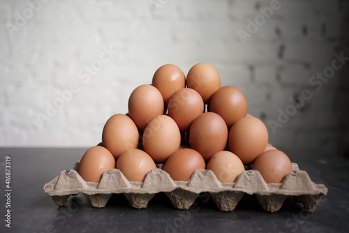 Pyramid of chicken eggs on a white wall background