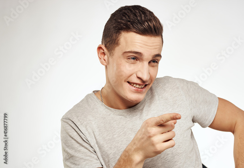 Cute man in t-shirt emotions close-up studio cropped view