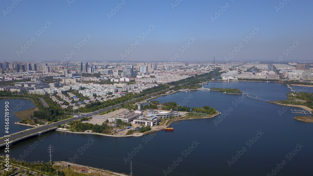Aerial view: City buildings by the water and skyline, China