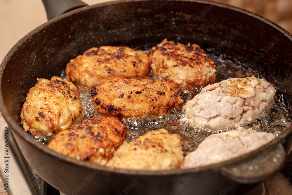 Minced beef cutlets are fried in a pan. Minced beef cutlets are fried in a pan.