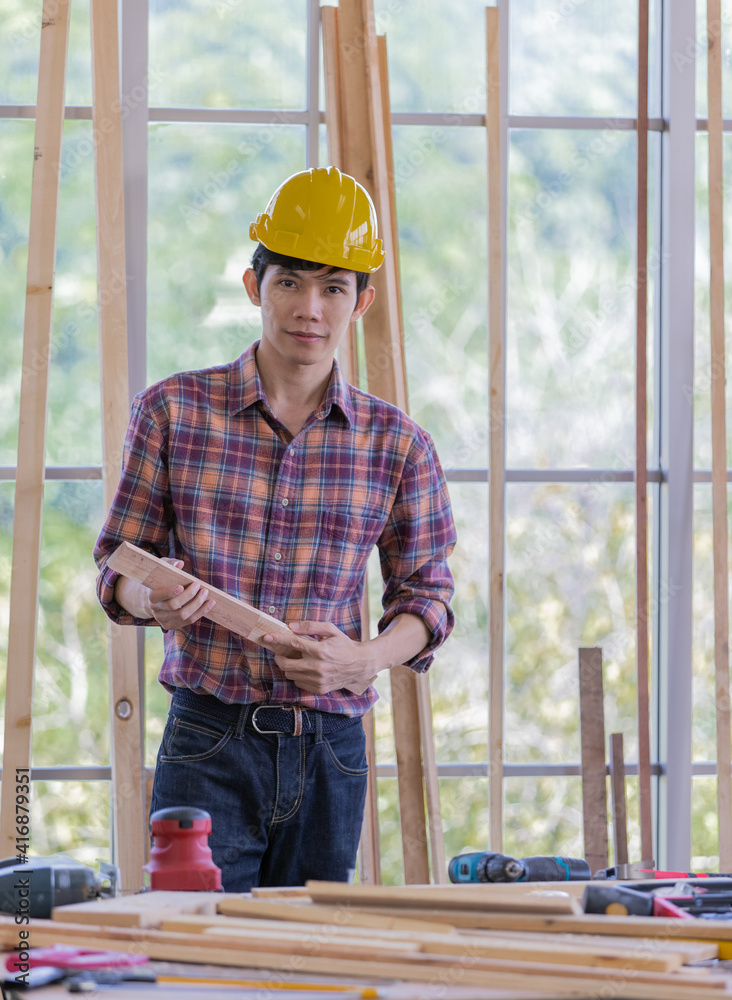young asian handsome male wearing orange hard safty helmet lean over working table full of equipments smiling inside industrial working site young asian handsome male wearing orange hard safty helmet lean over working table full of equipments smiling inside industrial working site
