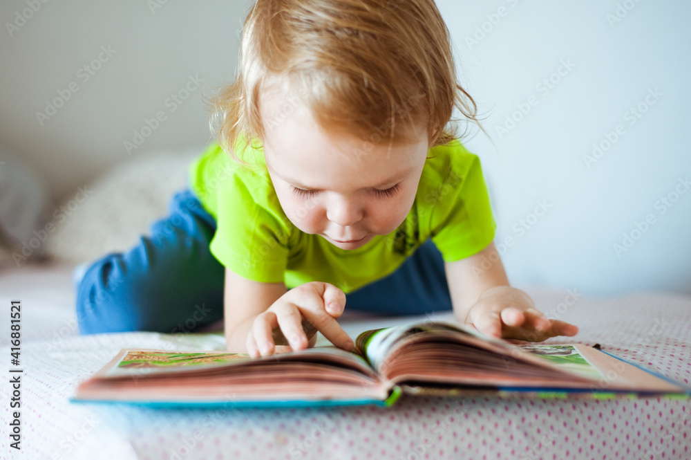 A small child enthusiastically reading a book. A love of books A small child enthusiastically reading a book. A love of books