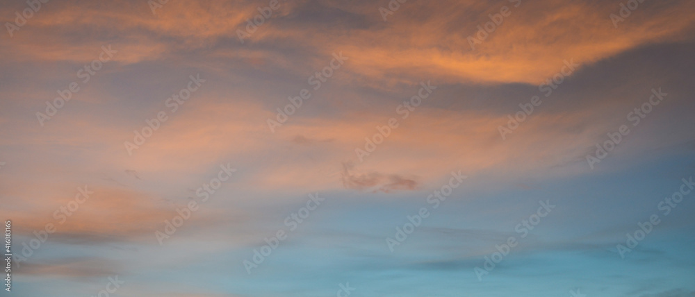 Bannière d'arrière-plan de texture de ciel au coucher du soleil, et légers nuages colorés jaune et rose sur fond de ciel bleu