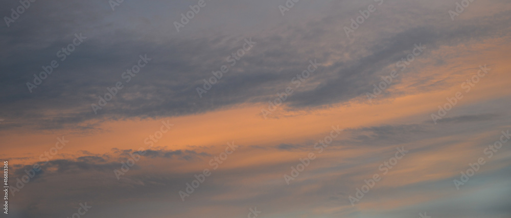 Bannière d'arrière-plan de texture de ciel au coucher du soleil, et légers nuages colorés orange et bleu foncé sur fond de ciel gris