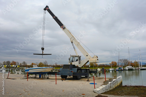 A hydraulic mobile suspended boat lift or hoist with a sling. Located in an out-of-season marina in northern Italy 