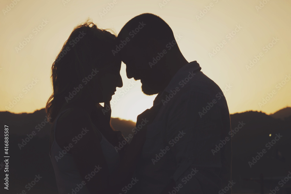 Loving couple enjoying honeymoon on beach sunset with luxury view walking shows emotion on sea background. Happy lovers on romantic trip fun on summer vacation evening. Concept romance and relaxation