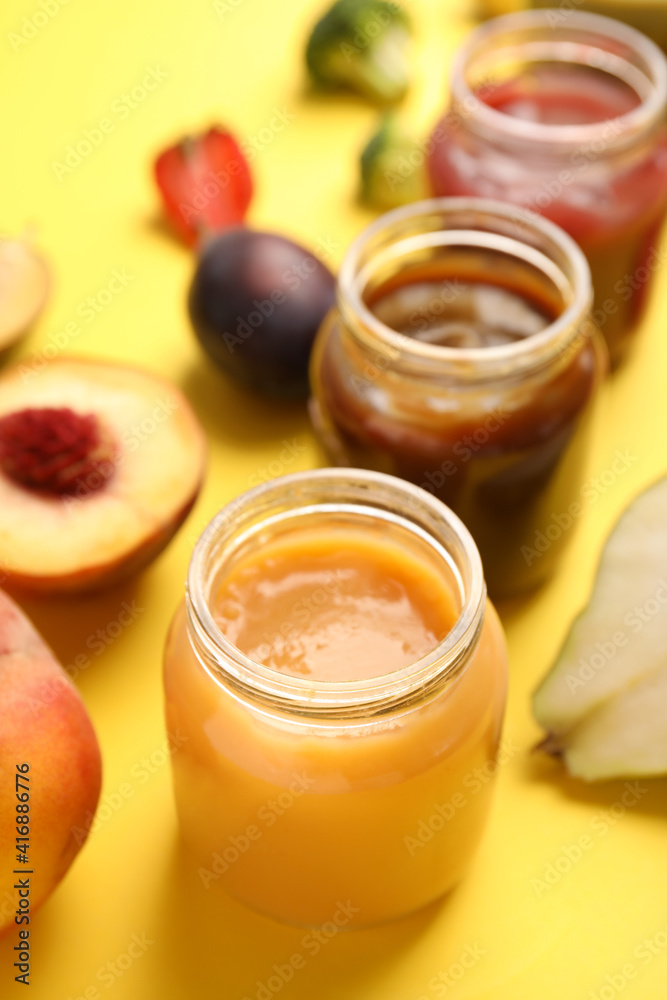 Healthy baby food and ingredients on yellow background