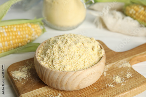 Corn flour in bowl on wooden board