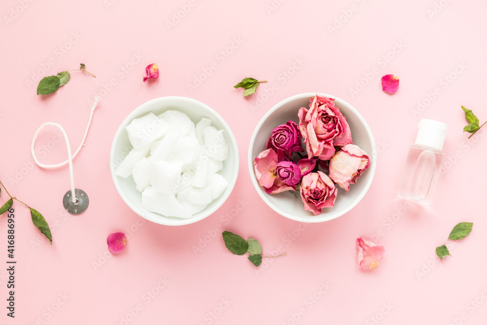DIY concept. Wax, wick, dry roses - ingredients for making handmade candles on a pink background. Flat lay. View from above. DIY concept. Wax, wick, dry roses - ingredients for making handmade candles on a pink background. Flat lay. View from above.
