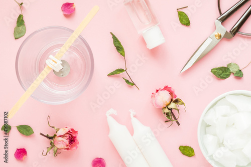 DIY concept. Wax, wick, dry roses - ingredients for making handmade candles on a pink background. Flat lay. View from above.