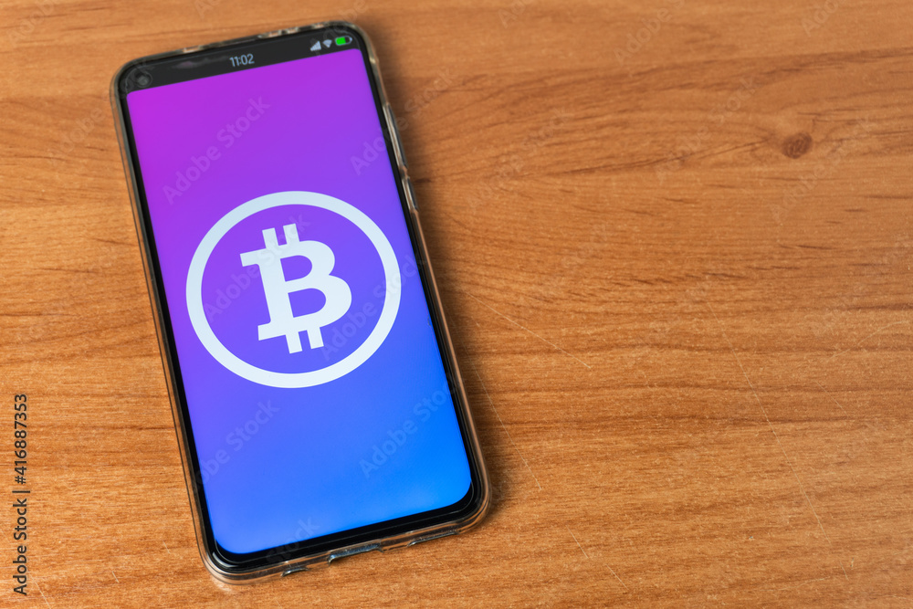 Phone with Bitcoin logo on table Phone with Bitcoin logo on table
