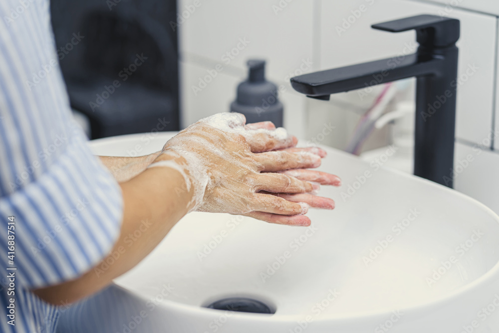 Closeup-up Asian woman hand washing with faucet water in Bathroom at home, Health care of Covid-19 pandemic , cleaning and carefree concept