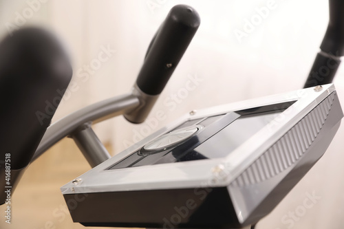 Control panel of modern elliptical machine cross trainer on blurred background, closeup