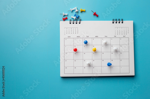 Calendar on solid ิblue background with copy space, pinned in a calender on datebusiness meeting schedule, travel planning or project milestone and reminder concept.
