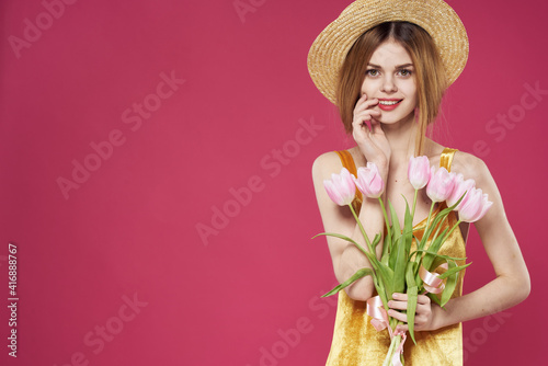 Woman in a hat with a bouquet of flowers as a gift for Valentine's Day holiday