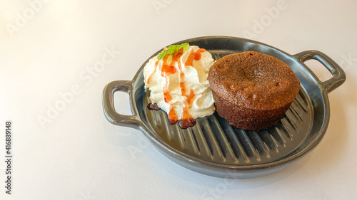 Chocolate cake with cream in the small pan on the white table