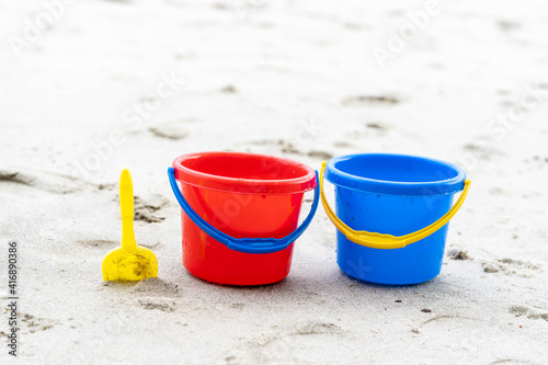 Children's beach toys - buckets, spade and shovel on sand on a sunny day