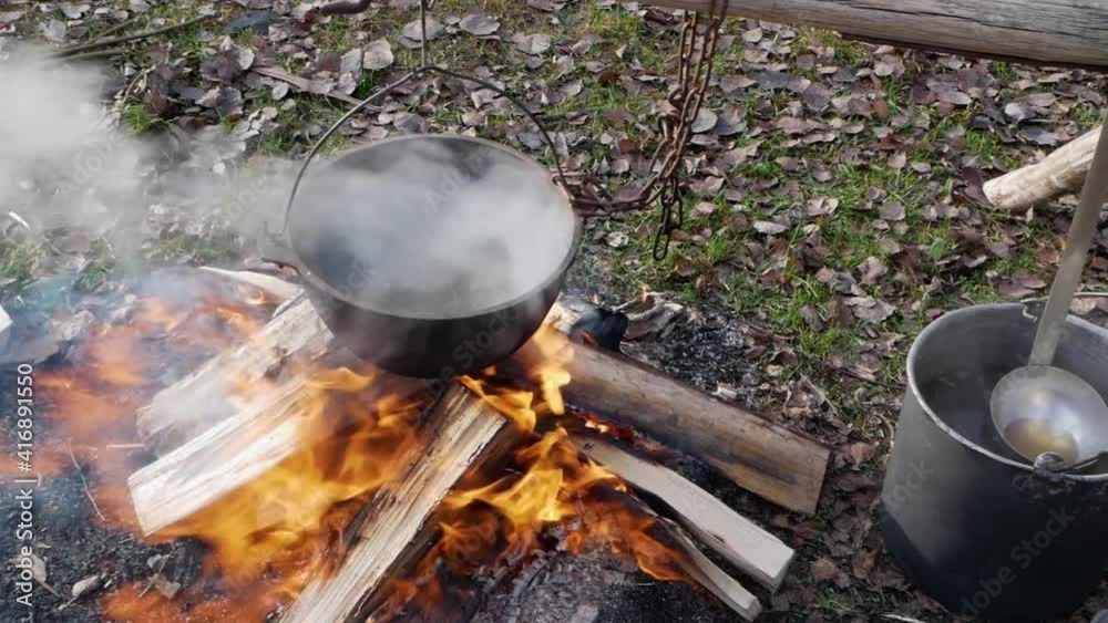 The cauldron with food on the fire. boiling water smoking. High quality FullHD footage The cauldron with food on the fire. boiling water smoking. High quality FullHD footage