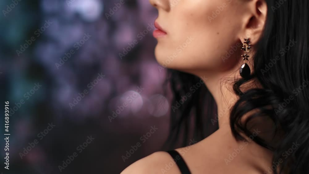 Closeup neck shoulder lips lady black jewelry earrings at lights disco. Shot with RED camera in 4K
