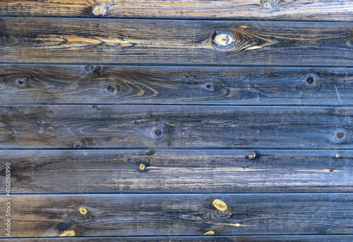 Wooden background from old boards. Natural pattern on wood. A combination of dark and light colors, hue blue, yellow.
