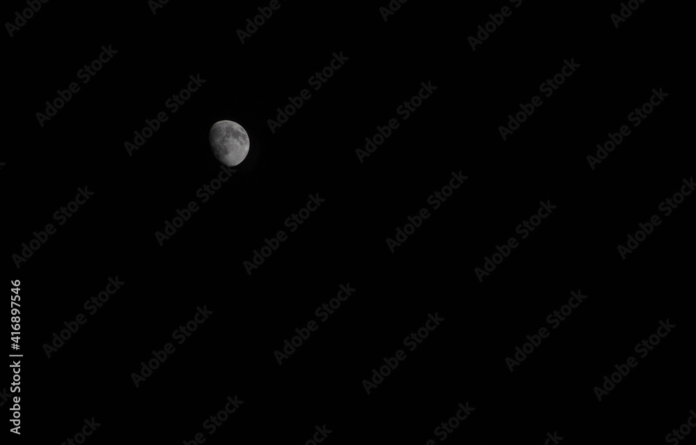 A white moon with craters against a dark sky. A white moon with craters against a dark sky.