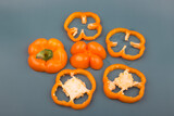 orange color bell pepper slices isolated on the grey background.