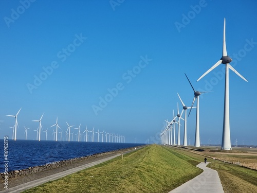 Windmill village indrustial wind mill by the lake Ijsselmeer Nehterlands. renewable energy green energy photo