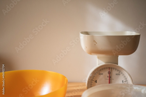 Feminine hands weighting flour on a anolog scale photo