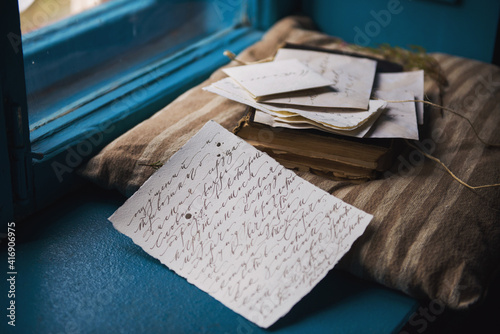 old love letters on the windowsill.with thoughts of the past days. past feelings and memories flooded in. the photo is stylized as vintage,a letter with a calligraphic handwriting copied from a novel photo