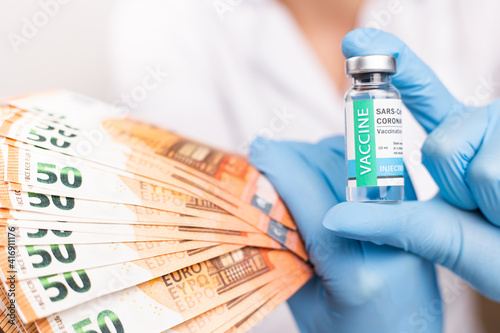 SARS - CoV2 Vaccination concept. Close up COVID-19 vaccine dose. A doctor or nurse in a laboratory holds a vial with a vaccine. Pandemic immunity. Money for the vaccine. photo