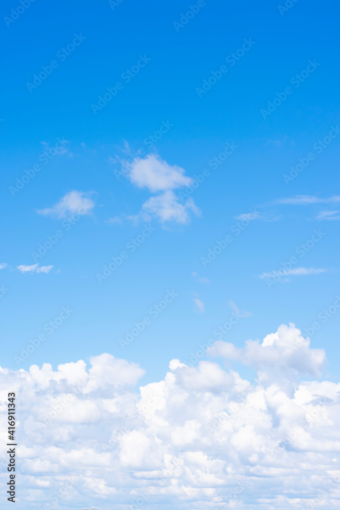 Vertical format of background made of lots fluffy  cumulus clouds on blue sky with gradient. Copy space