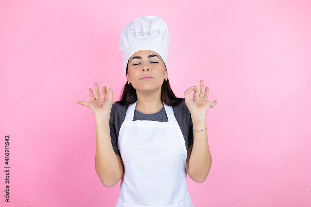 Young hispanic woman wearing baker uniform over pink background relax and smiling with eyes closed doing meditation gesture with fingers Young hispanic woman wearing baker uniform over pink background relax and smiling with eyes closed doing meditation gesture with fingers