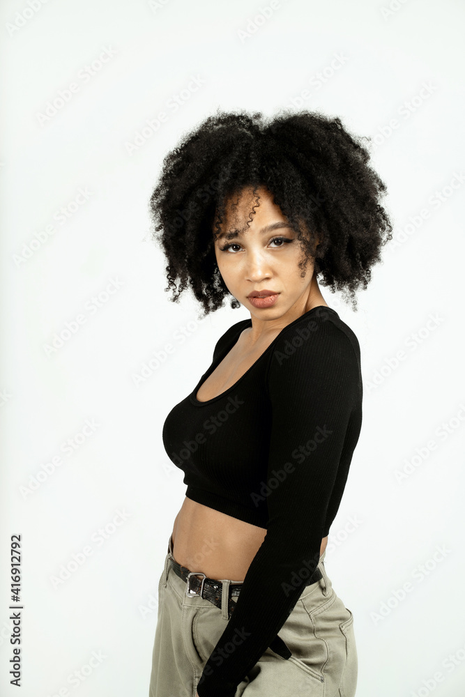curly-haired brunette in a black short jacket. copy space. a woman of Afro appearance poses in a photo studio on a white background. curly-haired brunette in a black short jacket. copy space. a woman of Afro appearance poses in a photo studio on a white background.