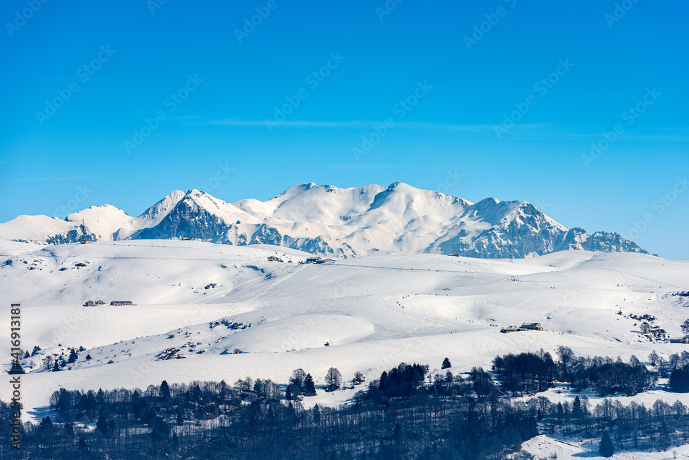 Lessinia High Plateau (Altopiano della Lessinia) and the Mountain range of the Monte Carega in winter with snow, also called the small Dolomites. Veneto and Trentino Alto Adige, Italy, Europe.