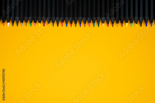 many pencils in different colors on yellow background