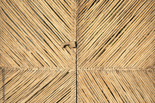 Tropical straw texture close-up. Unique pattern of handmade wicker fence. Tropical straw texture, wicker braided. Abstract background, unique rattan handmade pattern.
