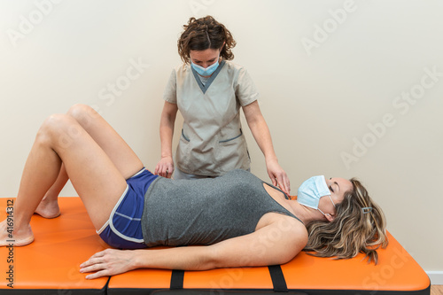 Принти на полотні Physiotherapist and patient in Global Postural Re-education session, with pandemic protection mask