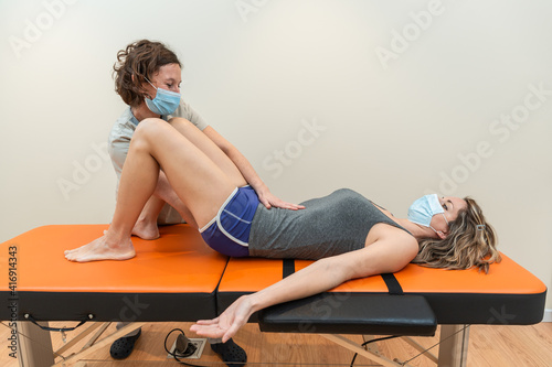 Картината върху платно Physiotherapist and patient in Global Postural Re-education session, with pandemic protection mask