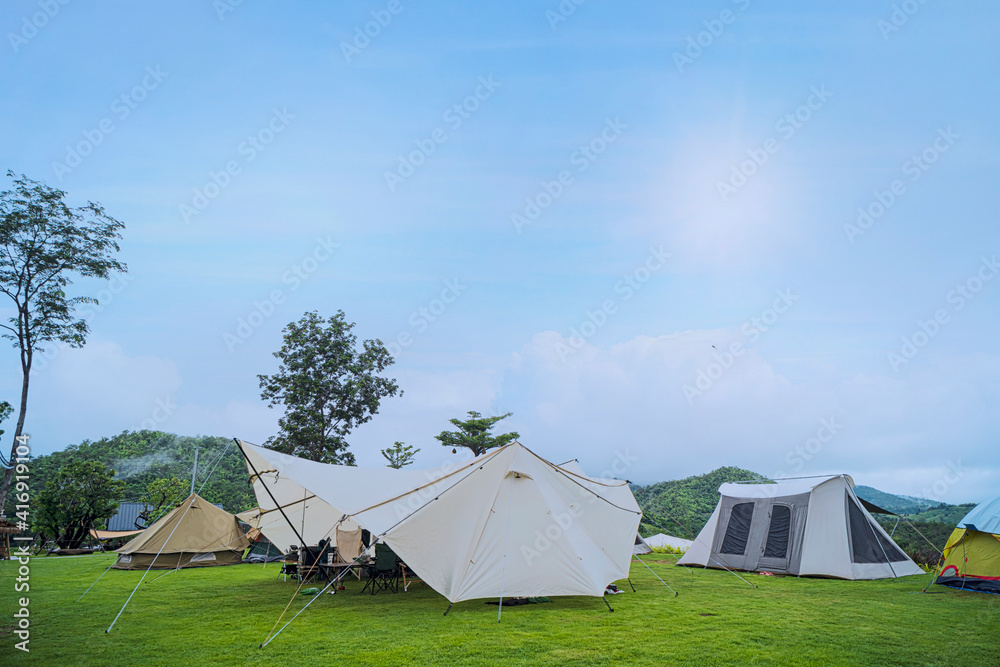 Camp and pitch a tent under the forest on the hill with a beautiful morning sun Camp and pitch a tent under the forest on the hill with a beautiful morning sun