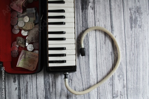 an old melodion (pianica) on a wooden table to earn money. photo