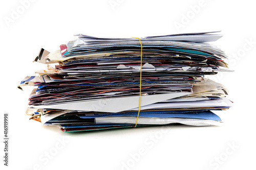 Photos Junk mail stacked high of unpaid bills closeup white isolated background